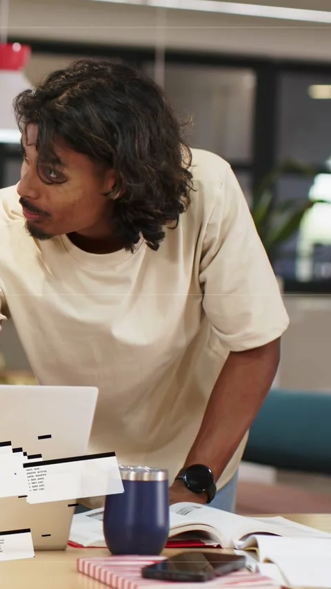 Vertical video: Man typing on laptop checking notes and phone while debugging Stock Footage 333556596