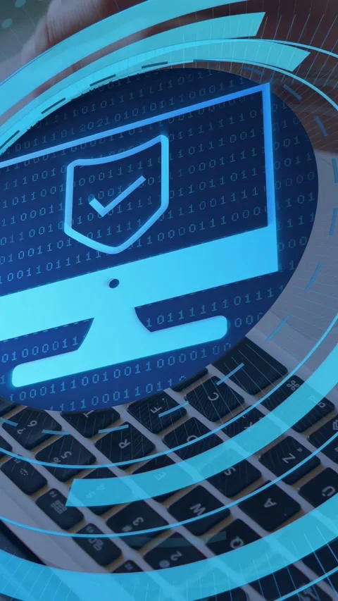 Vertical video: Man typing on laptop, initiating security HUD with shield icon Stock Footage 334694997