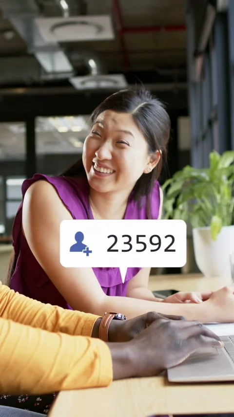 Vertical video: Man typing on PC, woman laughing, social icons popping around Stock Footage 333896142