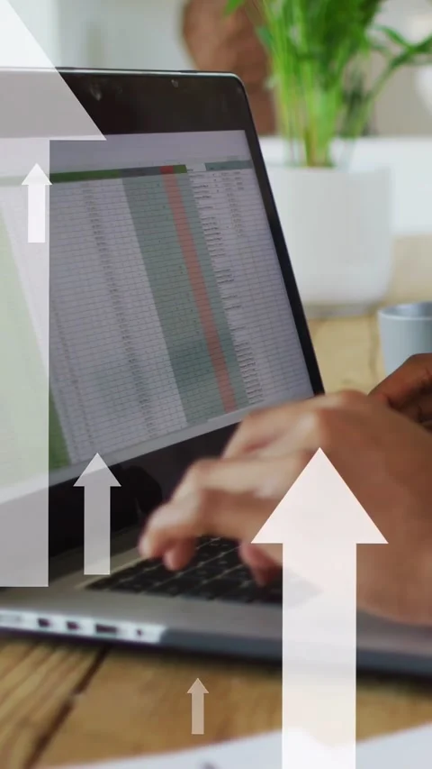 Vertical video: Man typing spreadsheet on laptop, causing upward arrows showing Stock Footage 335355740