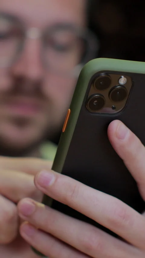 Vertical video. Man is using his smartphone sitting in the modern cafe. Stock Footage 345237564