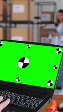 Vertical video. Man using laptop computer with green screen chromakey display Stock Photos