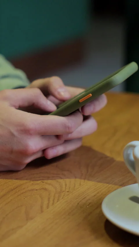 Vertical video. Man using smart phone in coffee shop. Stock Footage 345237828