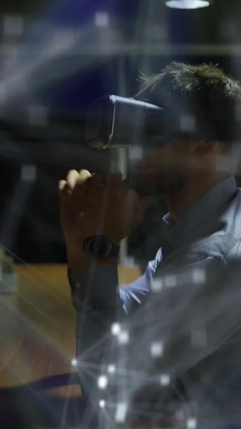 Vertical video: Man with VR headset gesturing in office, manipulating node graph Video stock 333487536