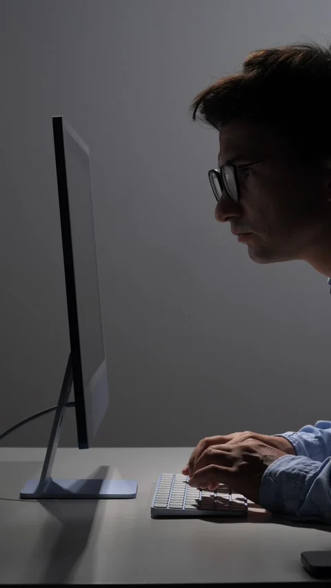 Vertical video man wearing glasses intently focusing on his computer screen Stock Footage 342672195