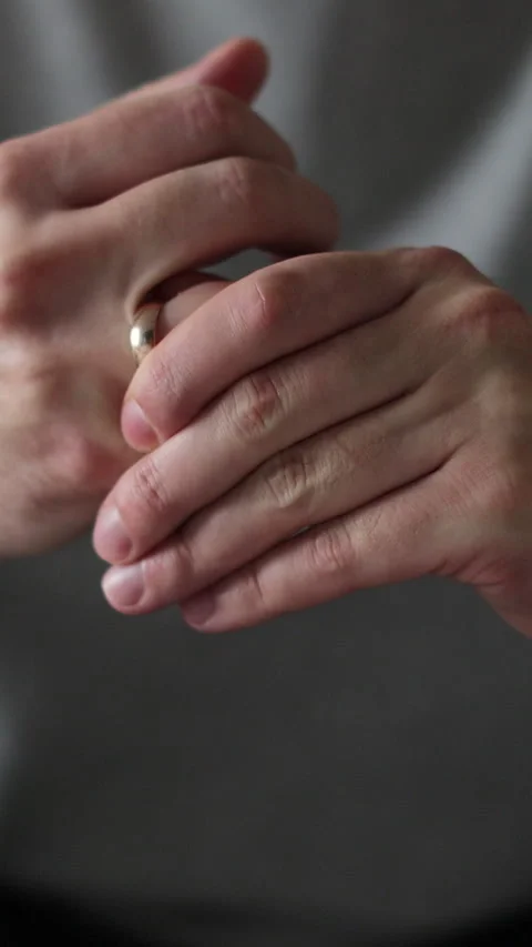 Vertical video Man wiggles his wedding ring on his finger. Stock Footage 337649470