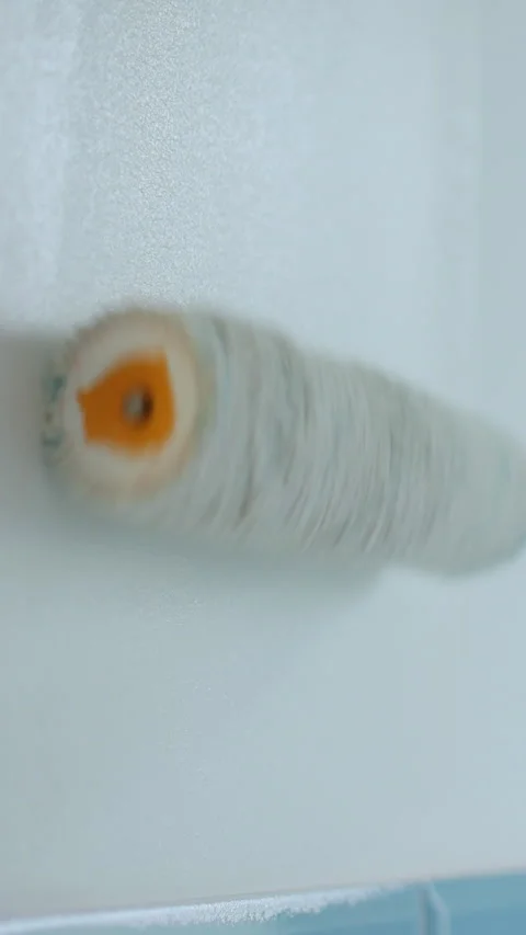 Vertical video Man worker using roller to paint the walls in the house Stock Footage 339059888