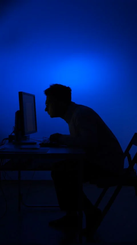 Vertical video Man working late at computer with blue light Stock Footage 318981250