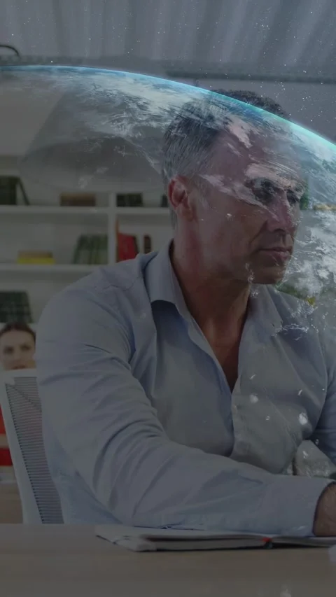 Vertical video: Man writing notes while globe graphic falling overlaying desk Stockbeeldmateriaal 333745605