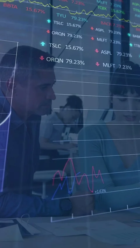 Vertical video: Manager leaning, analyst checking docs, market data fading Stock Footage 333487427