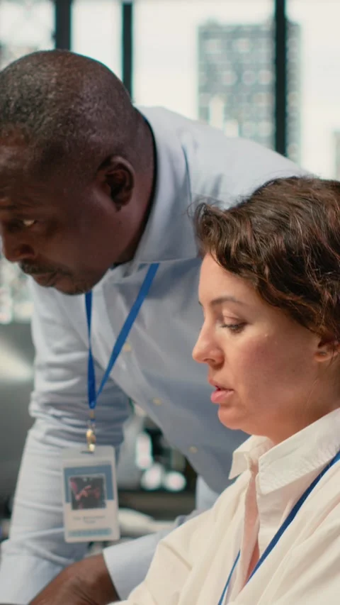 Vertical video Manager supervises intern in startup office using artificial Stock Footage 323142336