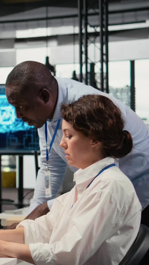 Vertical video Manager supervises intern in startup office using artificial Stock Footage 323236212