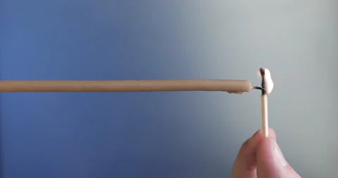 Vertical video. A man's hand lights a single candle with a match Stock Footage 143126073