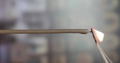 Vertical video. A man's hand lights a single candle with a match Stock Footage 143126112