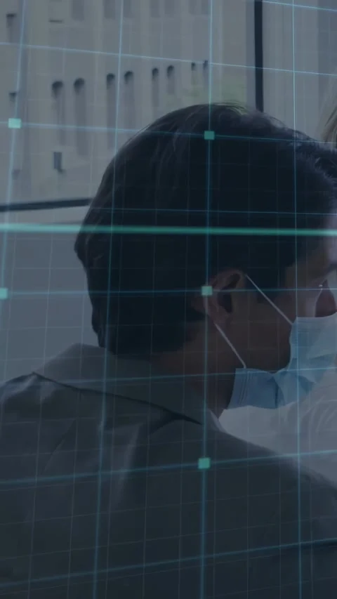 Vertical video: Masked man turning head toward talking co-worker in clinic teal Stock Footage 331030390