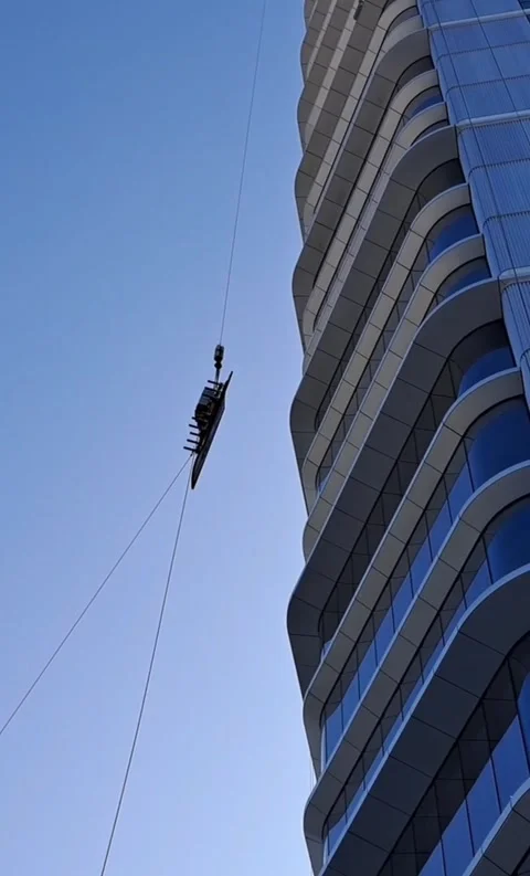 Vertical video of massive glass pane lifted in late afternoon Stock Footage 337359362
