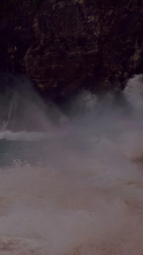 Vertical video. Massive Ocean Wave Exploding into White Spray at Kelingking Beac Stock Footage 337055589