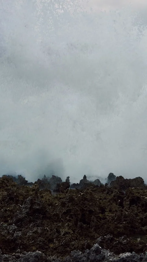 Vertical video. Massive Ocean Wave Exploding Over Sharp Coastal Rocks in Dramati Stock Footage 337061612