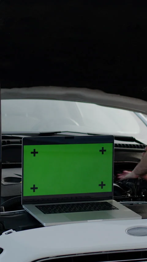 Vertical video. The master mechanic uses a laptop with a green color screen to Stock Footage 279807048