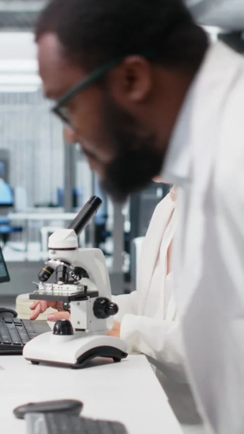 Vertical video Materials scientist operating compound microscope, studying 库存影片 319505344