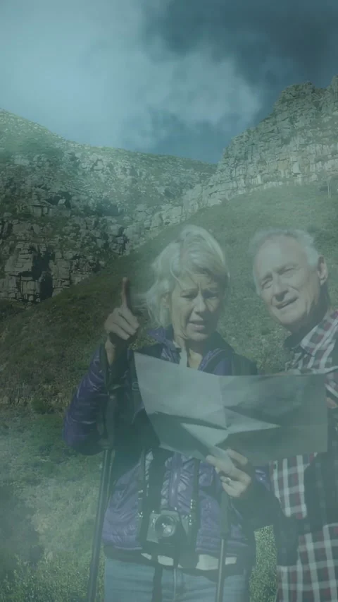 Vertical video: Mature couple reading map, woman pointing pole toward cliff, Stock Footage 333496231