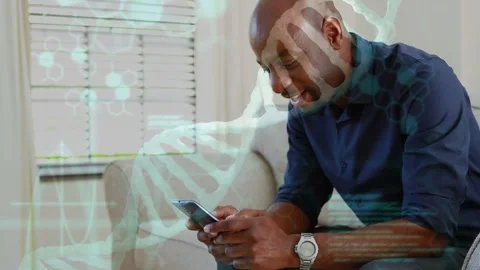 Vertical video: Mature man on couch tapping phone, viewing health DNA code Stock Footage 332772373