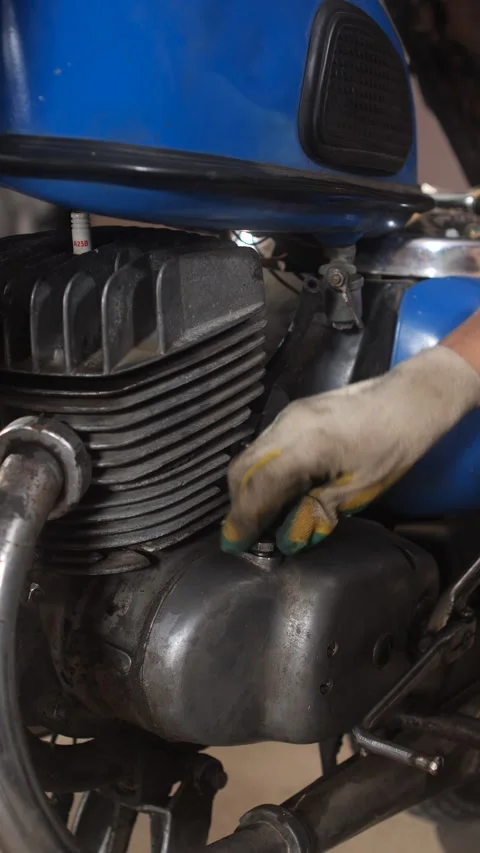 Vertical video mechanic hand wearing gloves working on a vintage motorcycle Stock Footage 342762642