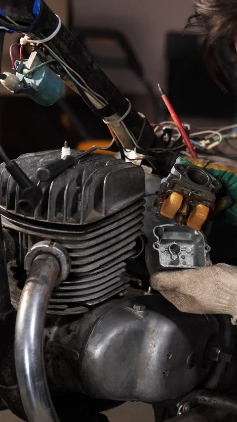 Vertical video mechanic wearing work gloves inspecting and repairing a vintage Stock Footage 342770394