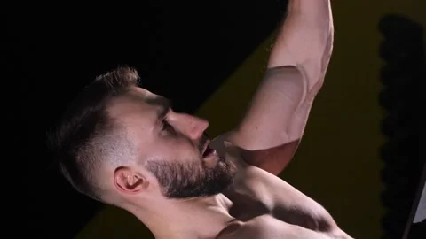 Vertical video. A men on a dark background in the gym doing cycling in the gym. Video stock 264765913