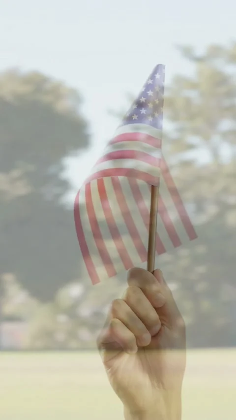 Vertical video: Men in park camera shifting to hand gripping and raising mini US Stock Footage 334046540