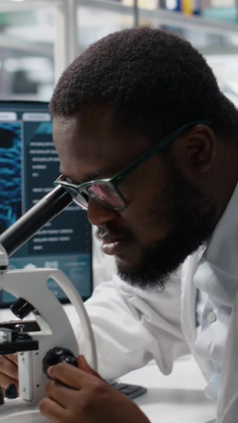Vertical video Microbiologist in lab inspects slide using optical device Stock Footage 319595751