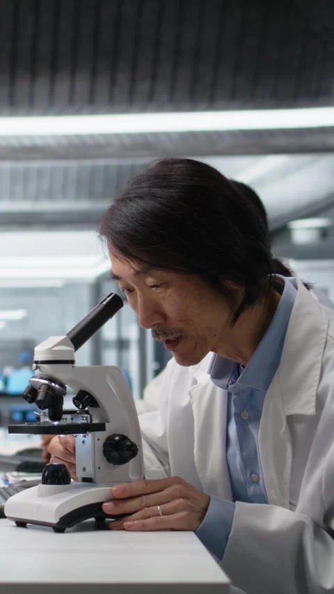 Vertical video Microscopist uses compound microscope to study genetic material Stock Footage 319505735