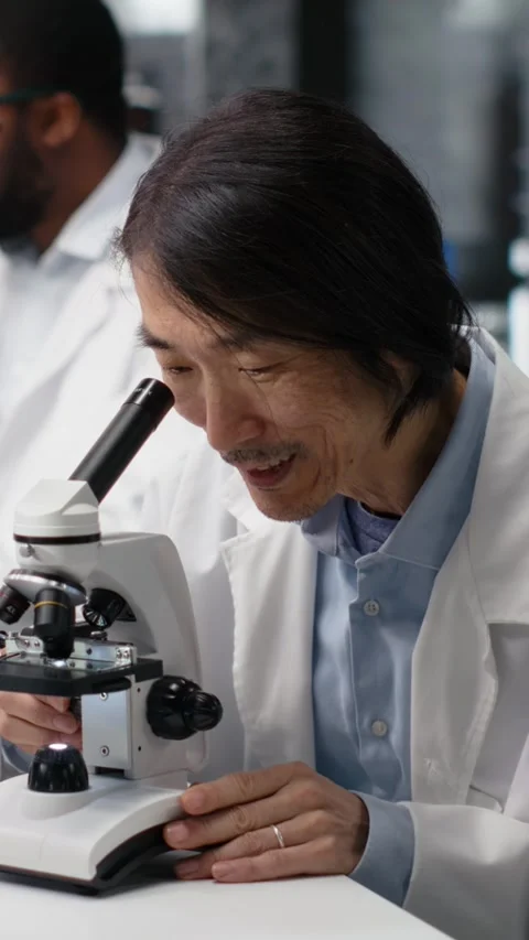 Vertical video Microscopist uses compound microscope to study genetic material Stock Footage 319594587