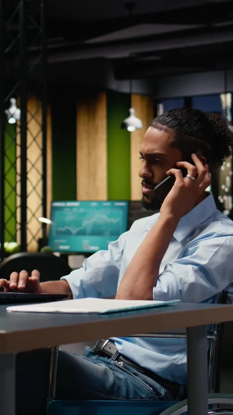 Vertical Video Middle Eastern businessman wheelchair user handling phone call Stock Footage 334104060