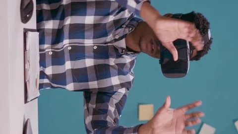 Vertical video: Millennial man using vr glasses with 3d visual simulation Stock Footage 172290774
