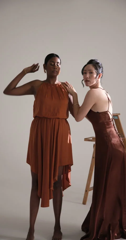 Vertical video: Models in elegant dresses posing confidently in fashion studio 스톡 동영상 310398627