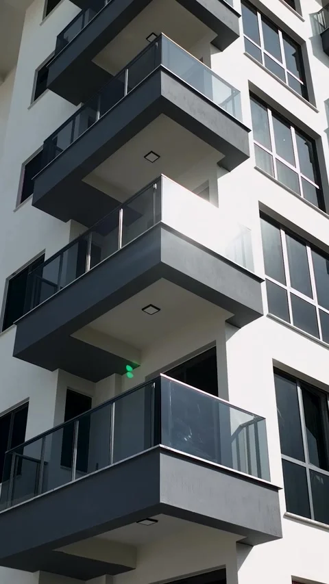 Vertical Video: Modern Glass Facade Reflecting Bright Sunlight with Elegant Stock Footage 297720170