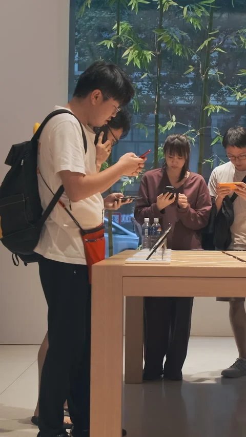 Vertical video: Modern smartphone Apple store showroom, customers explore iPhone Stock Footage 322516150