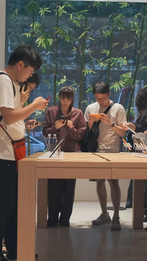 Vertical video: Modern smartphone Apple store showroom, customers explore iPhone Stock Footage 322516211