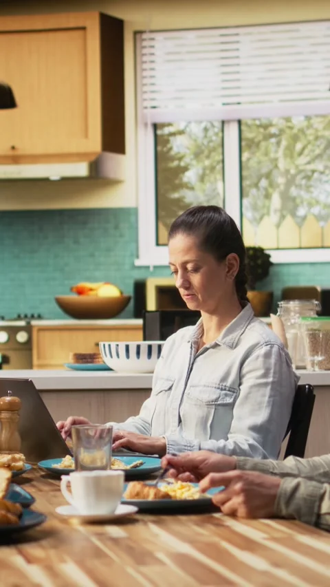 Vertical Video Mom doing remote work on laptop while pre-teen girl chats with Stock Footage 327098859