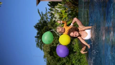 Vertical video. Mom splashes water and jumps with the child. Vacation in the Video stock 205099873