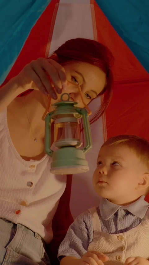 Vertical video Mother and son enjoy camping fun inside a colorful tent with a Stock Footage 329619802