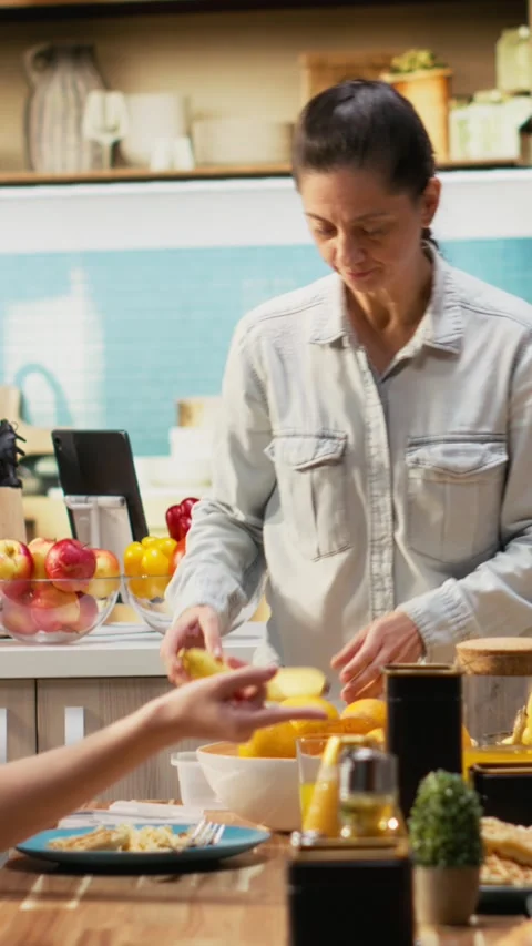 Vertical Video Mother preparing packed lunch in box for daughter at school Stock Footage 327170795