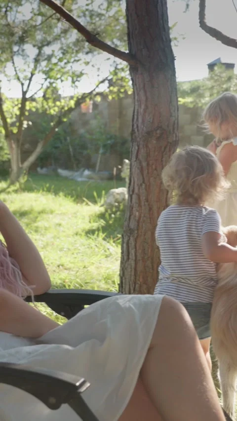 Vertical video. A mother with two daughters, a rabbit and a dog are in the Stock-Footage 283628730
