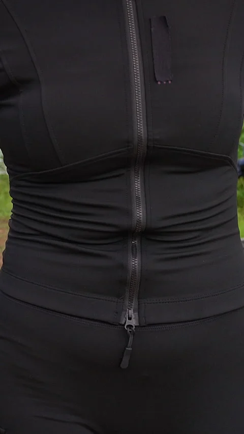 Vertical video. Motorcyclist Opens Black Riding Jacket to Reveal Yellow Back Arm Stock Footage 340645125