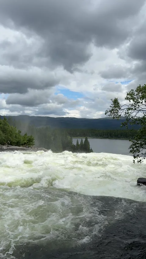 Vertical video of mountain river rushing through rocks with cloudy sky Video stock 315358539