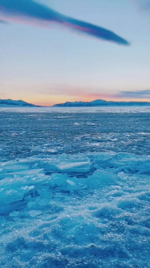 Vertical Video of Moving Blue Ice Shards on Sayram Lake Shore at Sunset Stock Footage 328389349
