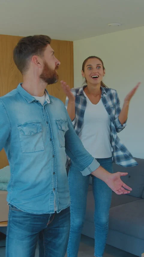 Vertical Video Moving into a new house. Happy couple holding a cardboard box Stock Footage 337995878