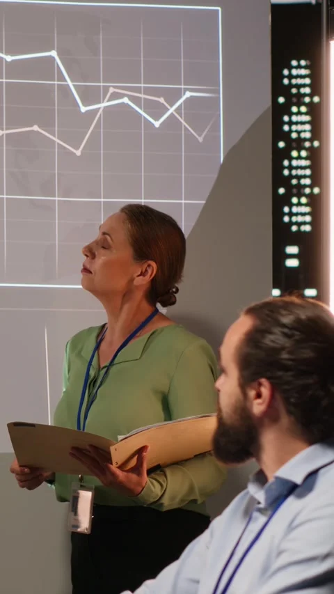 Vertical Video Multiethnic experts team evaluating data performance metrics on Stock Footage 314079728