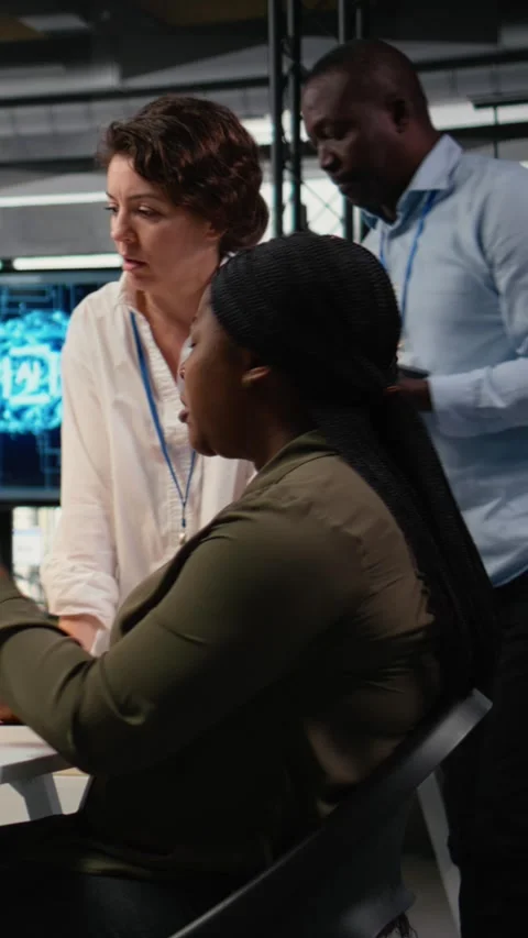 Vertical video Multiethnic technicians in startup office work with artificial Stock Footage 323330867
